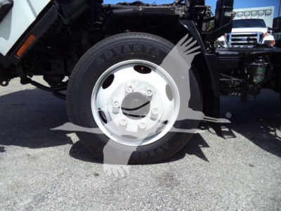 Isuzu NRR front wheel and suspension with Advanta tire and white steel rim visible.