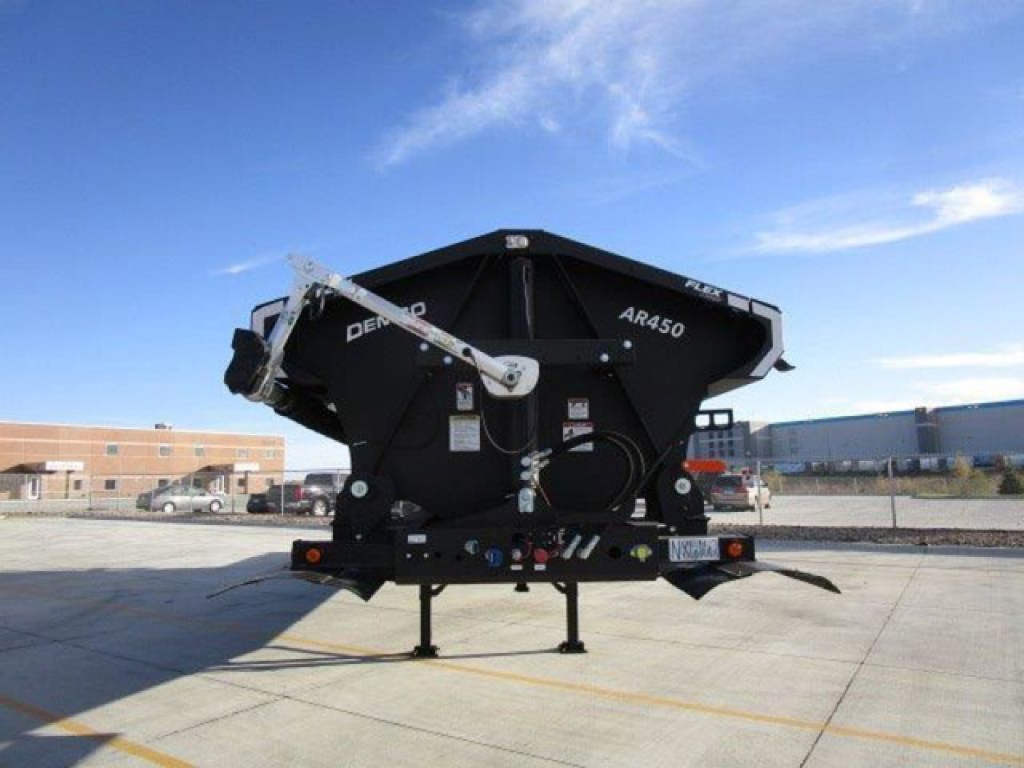 Demco AB450 dump trailer in front view showcasing black steel body and support legs.
