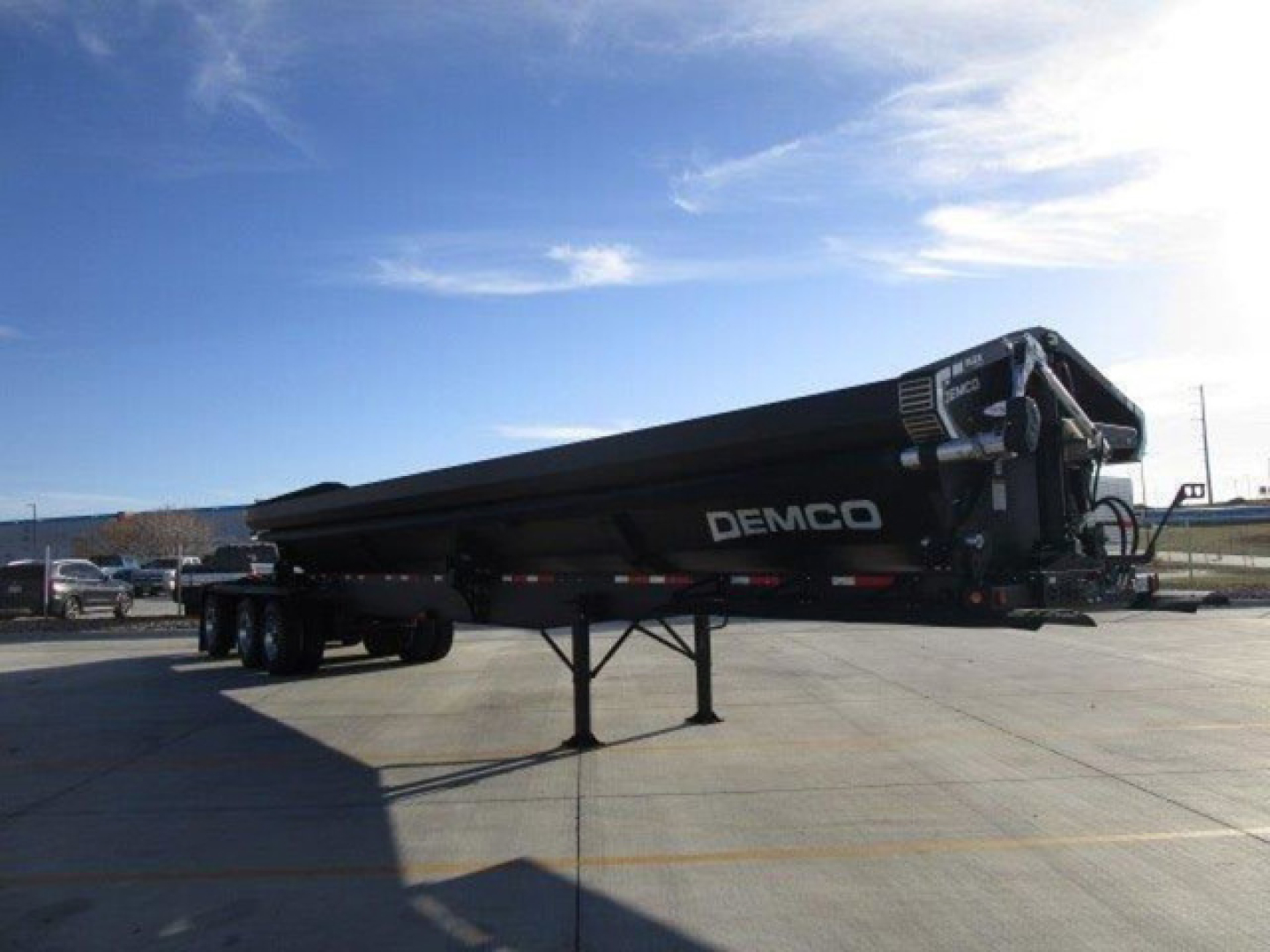 Demco dump trailer in-service view showing side profile with DEMCO branding on the tank.