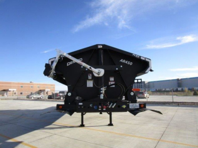 Demco AB450 dump trailer in front view showcasing black steel body and support legs.