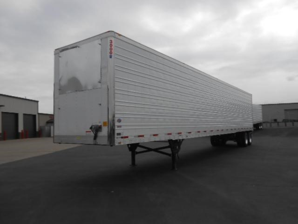 Utility 3000R trailer side and rear view showing aluminum ribbed walls, tandem axles, landing gear, and rear doors.