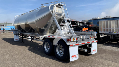 Heil cement mixer trailer/tanker in silver with dual wheels, rear lights and ladders; side text unreadable, but shows Heil brand mud flaps.