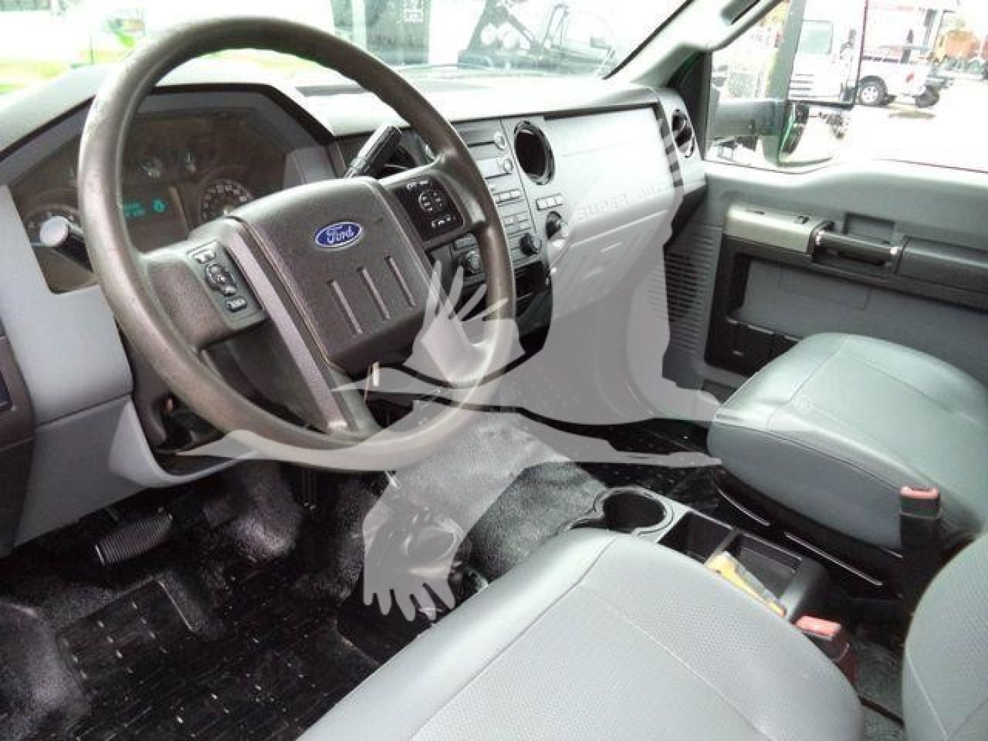 Ford truck interior showing steering wheel with Ford emblem, dashboard, center console, and front seats.