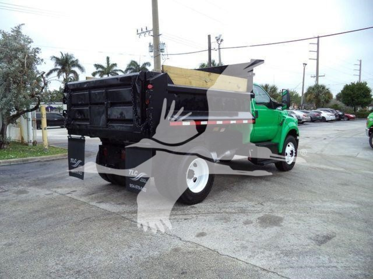 Truck bed of a Ford F650 SD dump truck showing rear/side view with green cab and black dumping box.