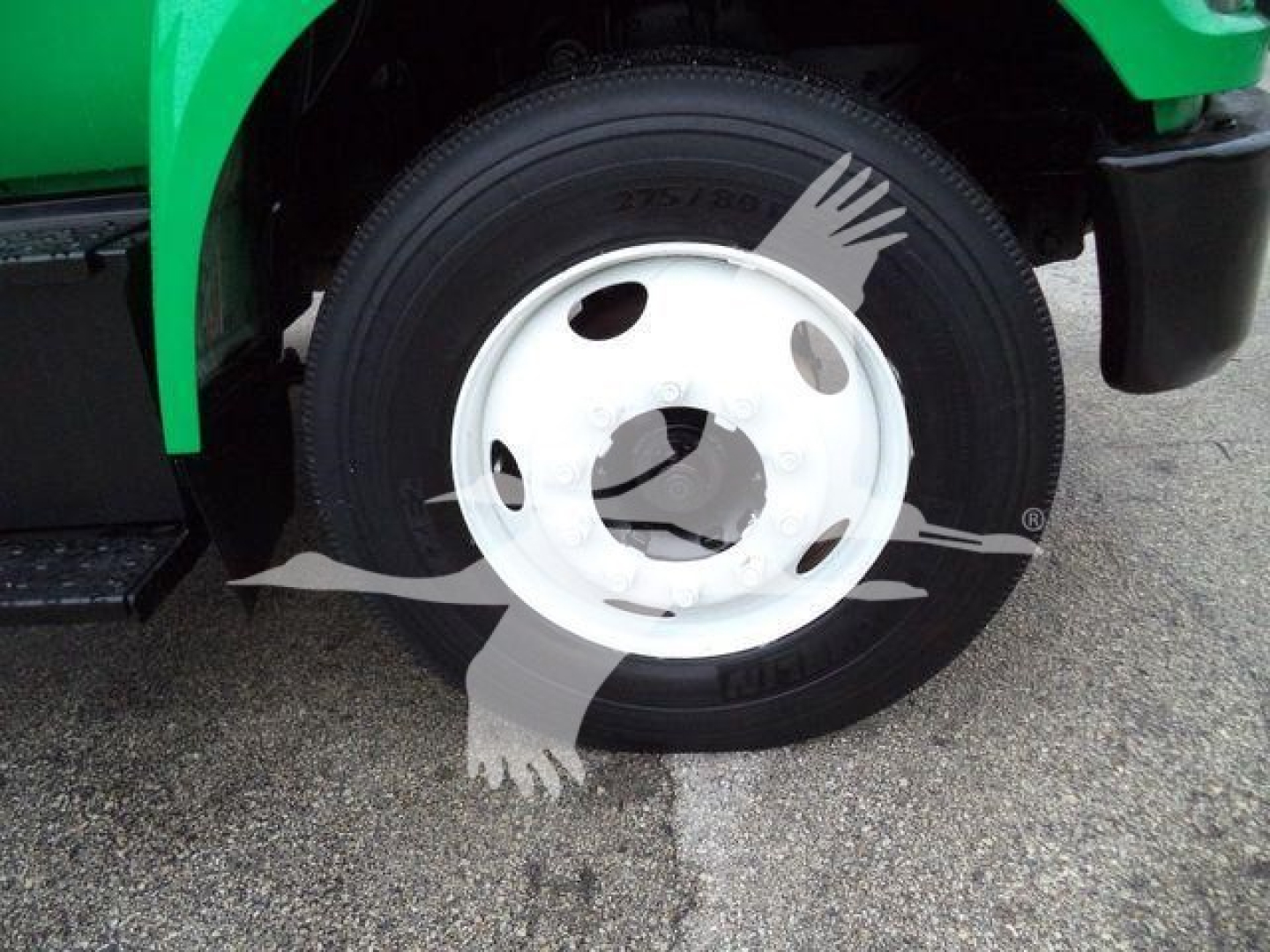 Truck front wheel and fender area of a 2017 Ford F650 SD dump truck showing a white steel wheel and tire.