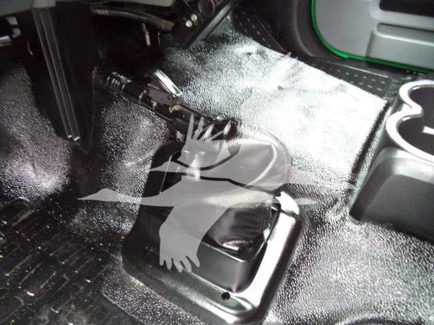 Shift lever area inside Ford F650 SD cab showing gear selector boot and surrounding floor with textured rubber mat and cup holders.