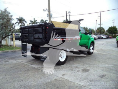 Truck bed of a Ford F650 SD dump truck showing rear/side view with green cab and black dumping box.