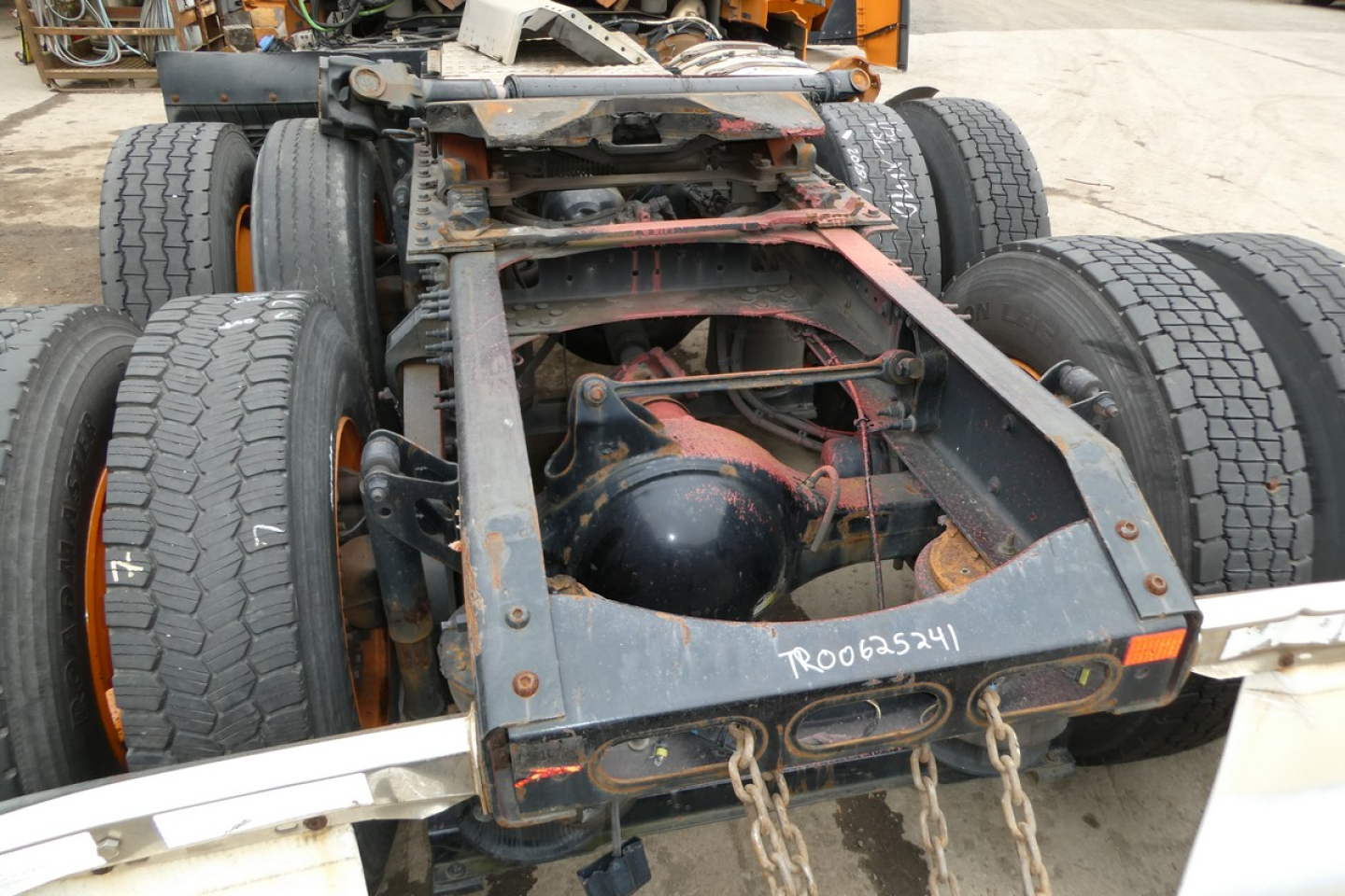 Frame and rear axle of a Volvo VNR64T300 truck chassis showing dual rear wheels, drivetrain, and fifth wheel area with visible maintenance markings.