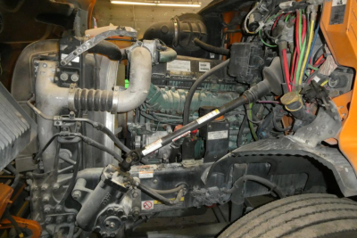 Volvo VNR64T300 engine bay showing diesel engine, coolant hoses, wiring harness, and air intake components.