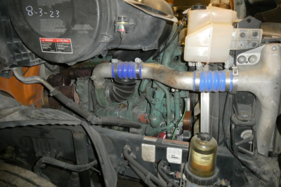 Volvo VNR64T300 engine bay showing coolant reservoir, hoses with blue couplers, and fuel/air system components.