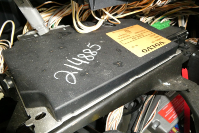 Module in Volvo VNR64T300 engine bay wiring harness with label and handwritten numeric 214885.