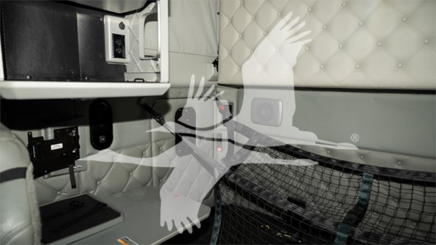 Kenworth T680 cab interior showing quilted sleeper panel and storage area with warning labels, light gray upholstery, and step into cab.