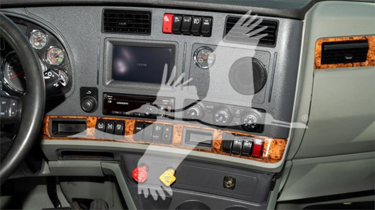 Kenworth T680 interior dash showing center touchscreen, wood trim, HVAC controls, gauges, and steering wheel.