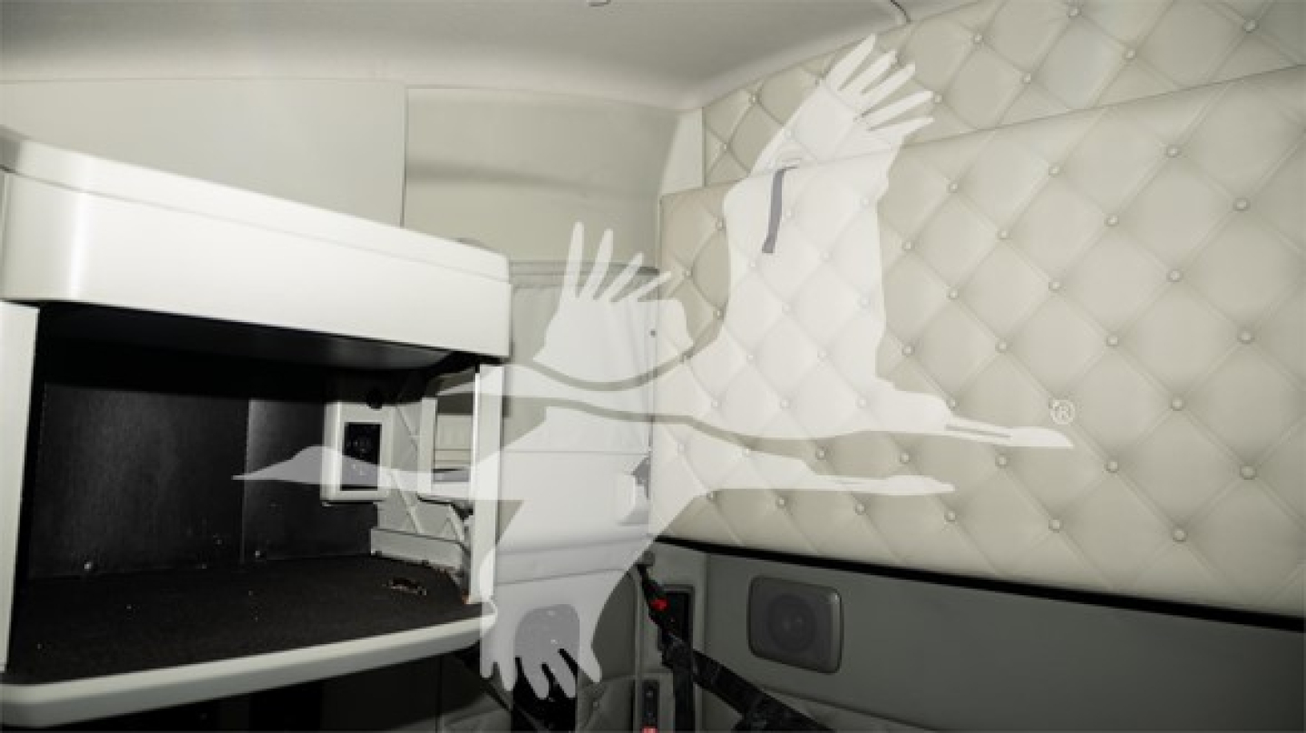 Kenworth interior view showing sleeper cab with quilted padded wall and overhead cabinet in a truck interior.