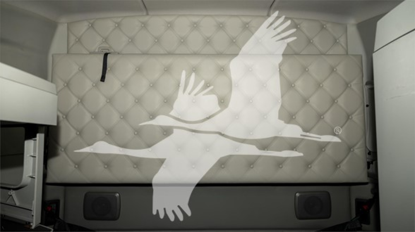 Kenworth T680 sleeper cab side with large white geese-like graphic on quilted panel; no visible text other than the graphic.