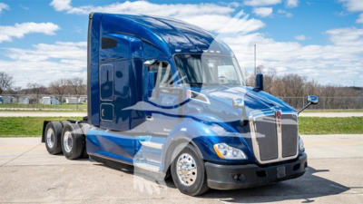Kenworth T680 sleeper cab truck in blue with chrome grille and dual rear axles, side view showing logo and windows.