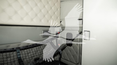 Kenworth T680 sleeper cab interior showing quilted upholstery and door area.