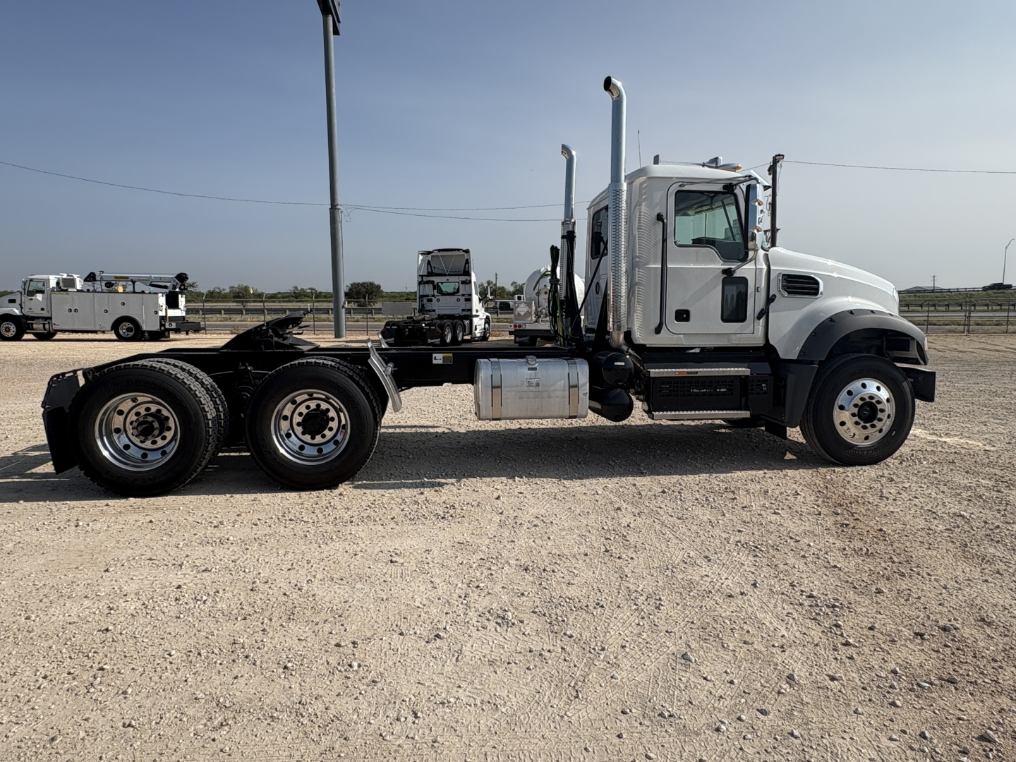 Truck chassis side view showing Mack GR64FT cab with dual rear axles and fuel tank; no engine details visible.