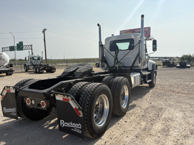 Truck chassis and cab of a new 2027 Mack GR64FT daycab showing rear axles and fifth-wheel area.