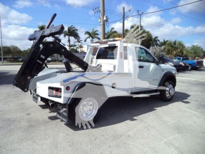 Truck bed with hydraulic tow winch system on Ram 5500 SLT, white crew cab, with heavy duty rear equipment and wheel chocks visible.