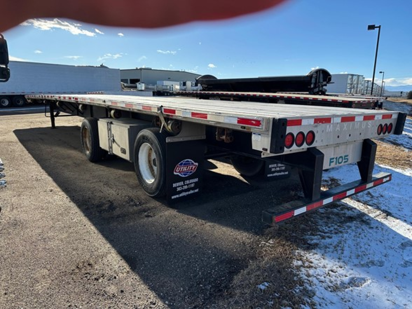 Flatbed trailer showing dual rear wheels and metal deck with reflective tape and Lights, California legal 2019 Transcraft combo flatbed trailer undercarriage and bumper guards.