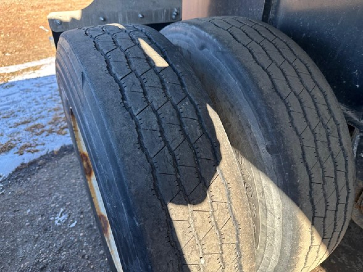 Trailer tires visible with wear on tread in front of wheel fender.