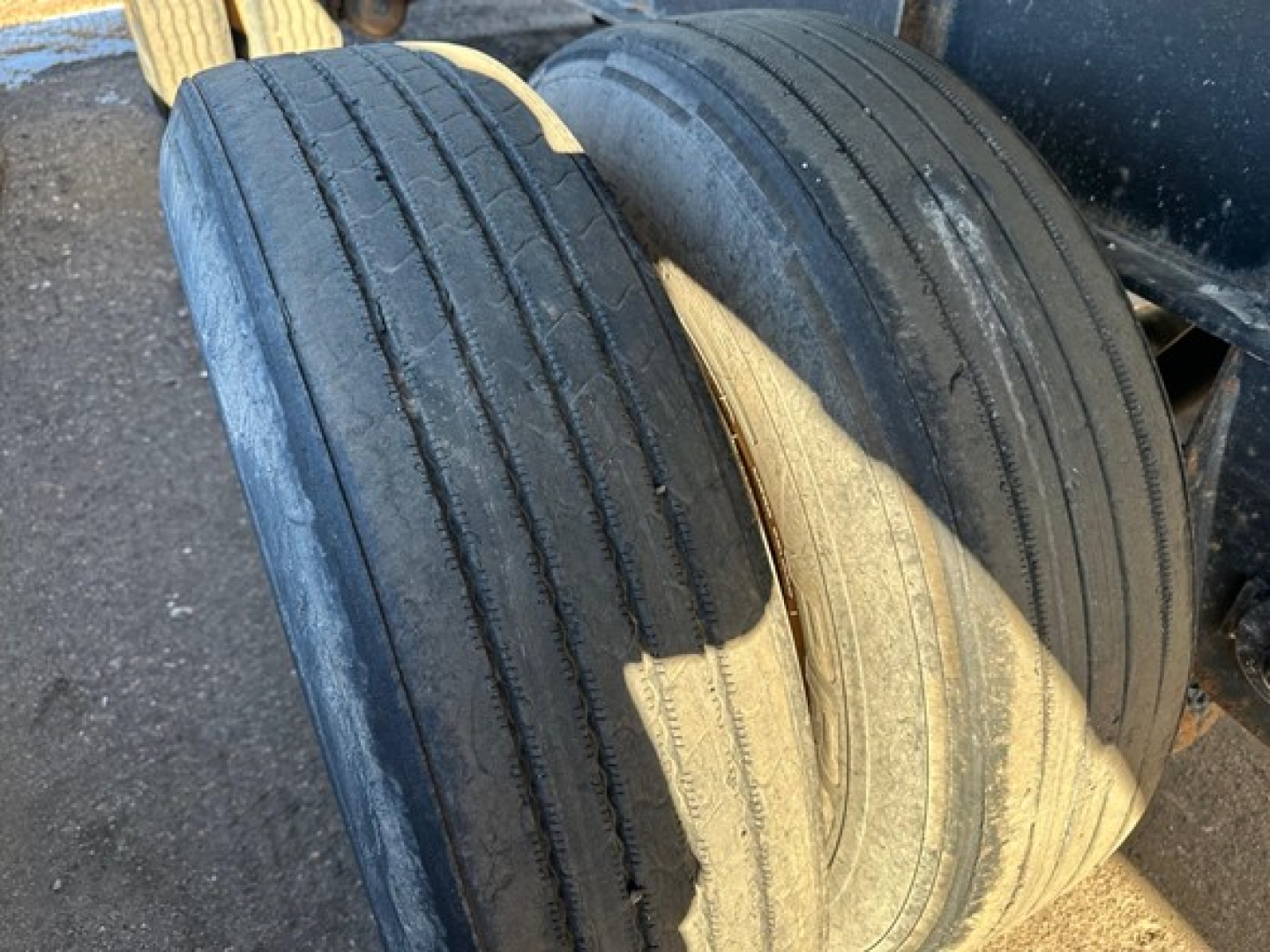 Trailer wheelset showing two large tires with tread wear and sidewall markings.