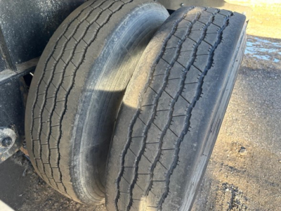 Dual rear tires on a Transcraft flatbed trailer showing tread wear and sidewall details.