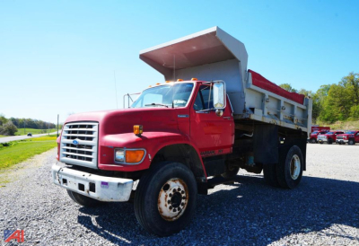 Ford F-80 dump truck in service showing red cab and large steel dump bed with white sides.