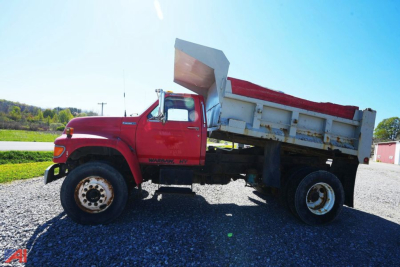 Ford F80 dump truck side view showing red cab and white dump bed with raised tailgate.