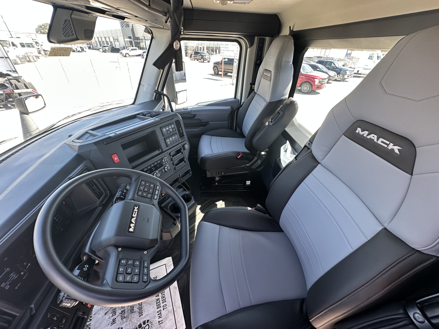 Mack AN64T truck interior showing driver's seat and steering wheel with dashboard and passenger seat.
