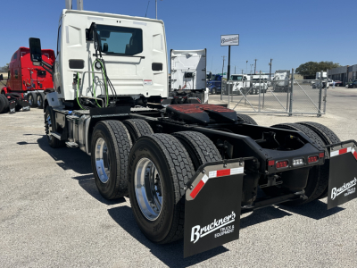AMC Mack AN64T chassis with cab and rear 6x4 tractor configuration; spare wheel wells; visible mud flaps with Buckner's Truck & Equipment logos; white cab with green hoses and black chassis, dual rear axles.