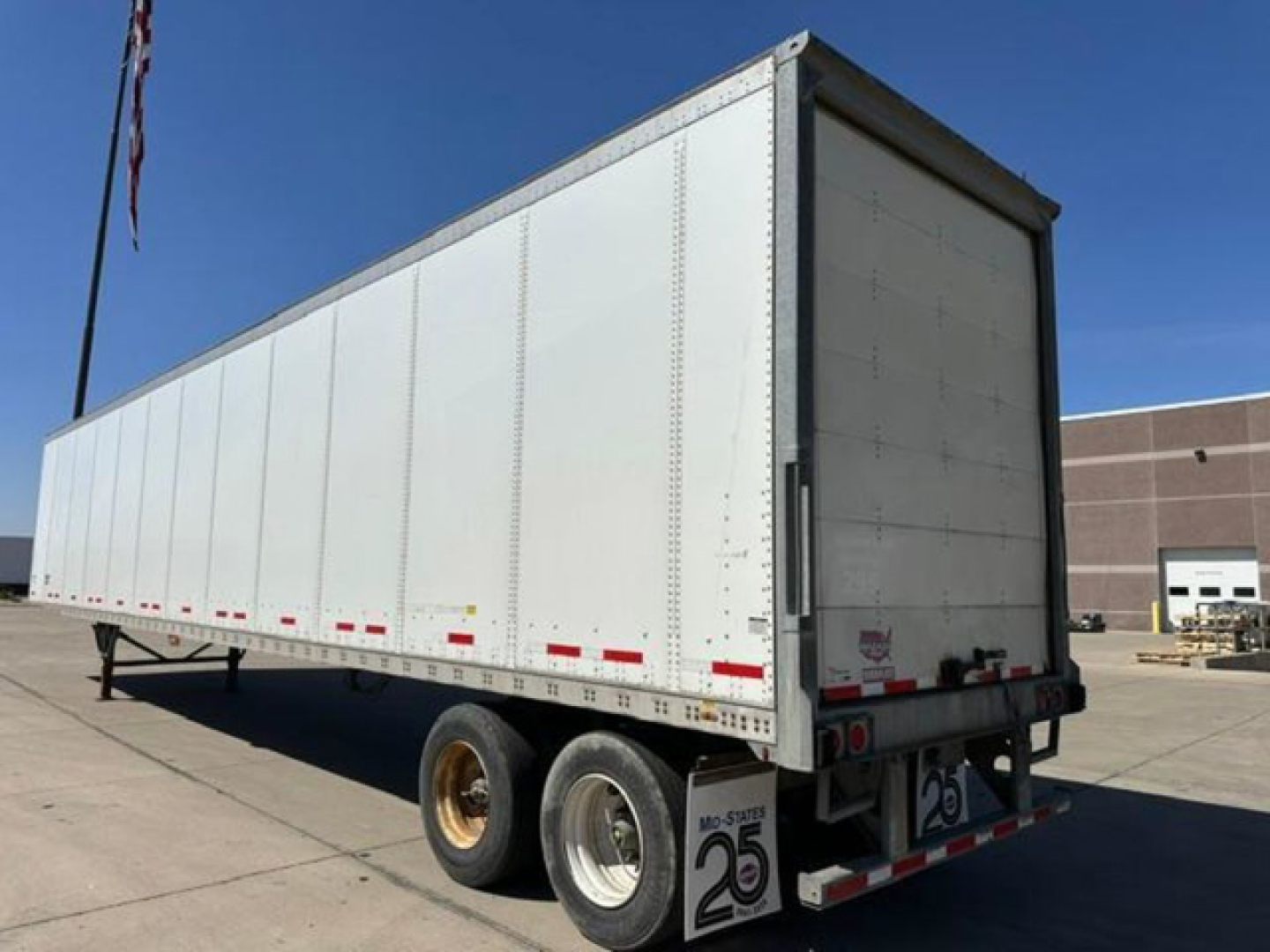 Trailer side view showing a white Wabash van trailer with dual rear wheels and a closed rear door. VIN 1JJV532D7GL908633, stock U90903.