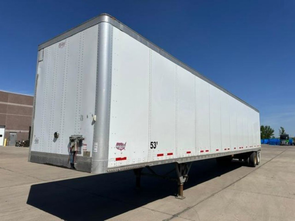 Trailer side view showing a white 53' Wabash van trailer with silver corner posts and rear impact guard.