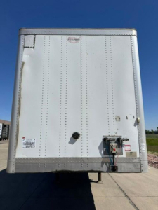 Rear view of a white Wabash trailer showing doors and connectors.