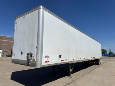 Trailer side view showing a white 53' Wabash van trailer with silver corner posts and rear impact guard.