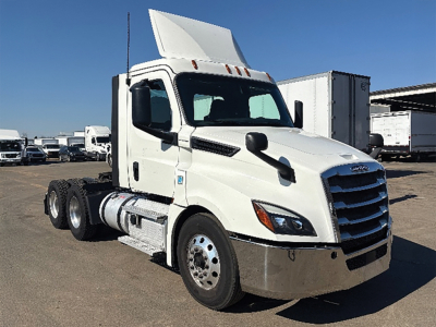 Truck cab in yard showing 2019 Freightliner Cascadia126 with white exterior and raised sleeper, emblem grille, side mirrors, and chassis behind