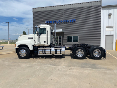 Mack PI64T conventional daycab truck side view showing white cab and dual rear axles.