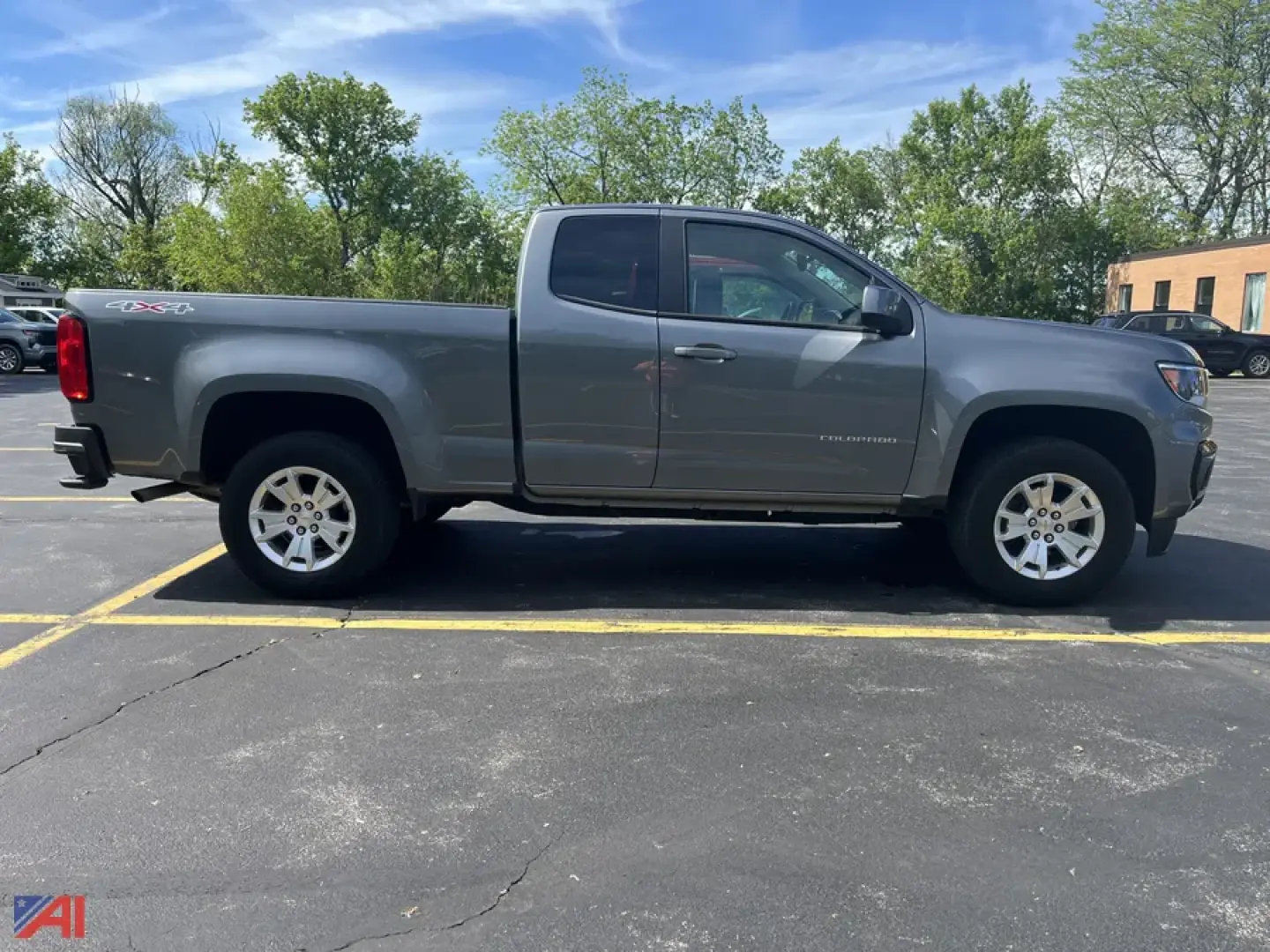 Side view of a gray 2022 Chevrolet Colorado extended cab pickup truck in a parking lot.