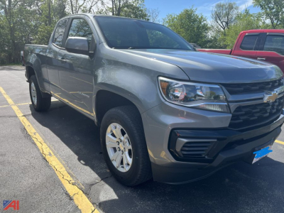 Chevrolet Colorado crew cab pickup truck in a parking lot, side/front view, silver with black grille, Chevrolet bowtie emblem on grille, alloy wheels, 4x4.