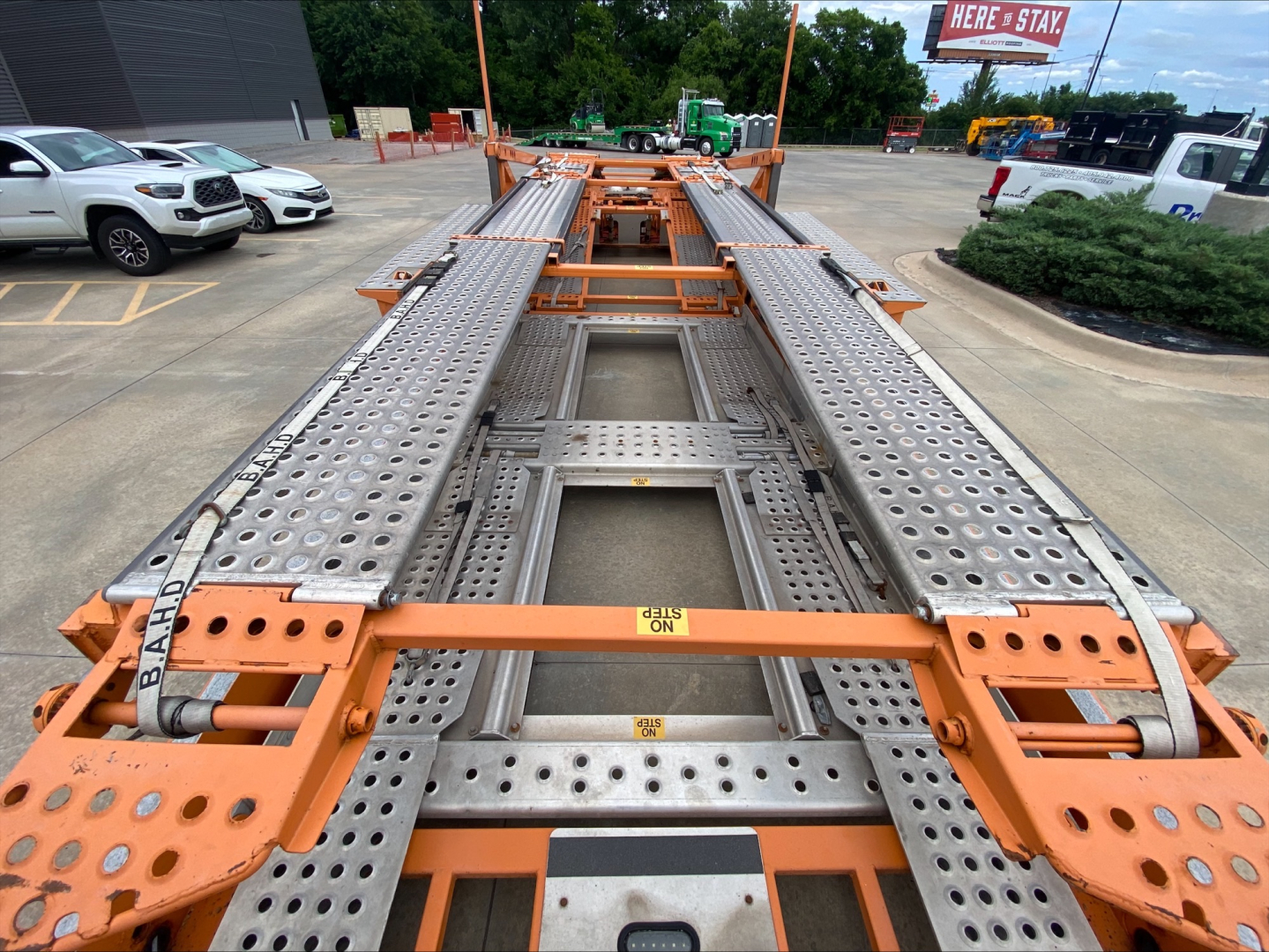 Truck trailer bed with perforated steel deck and orange-painted frame showing a car carrier trailer from Volvo VAH 2014.
