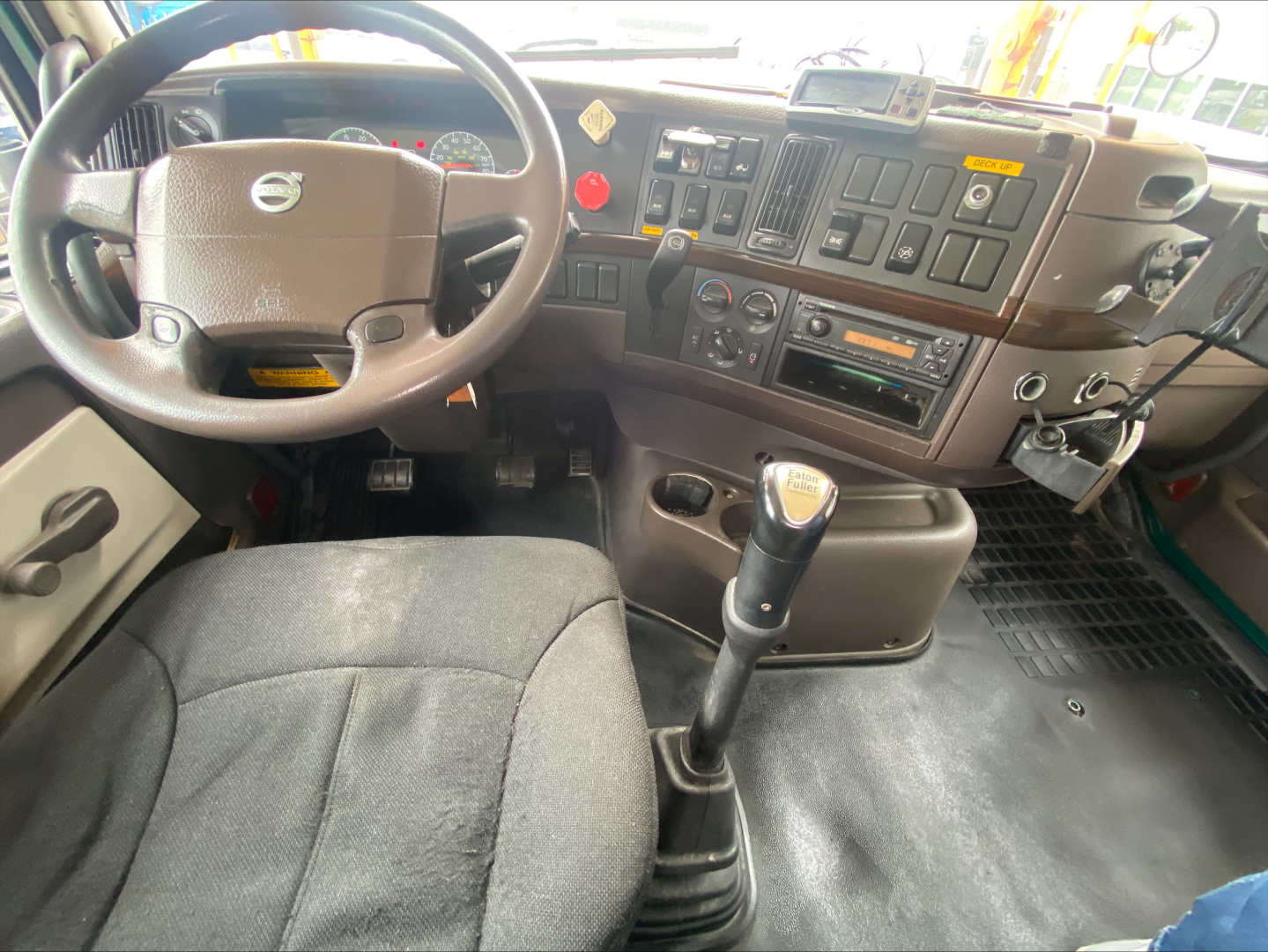 Interior of a Volvo VAH cab showing steering wheel, dashboard with gauges, gear shifter, and center console.
