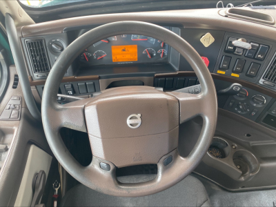 Volvo VAH truck cockpit showing steering wheel, dashboard gauges, and control panels.