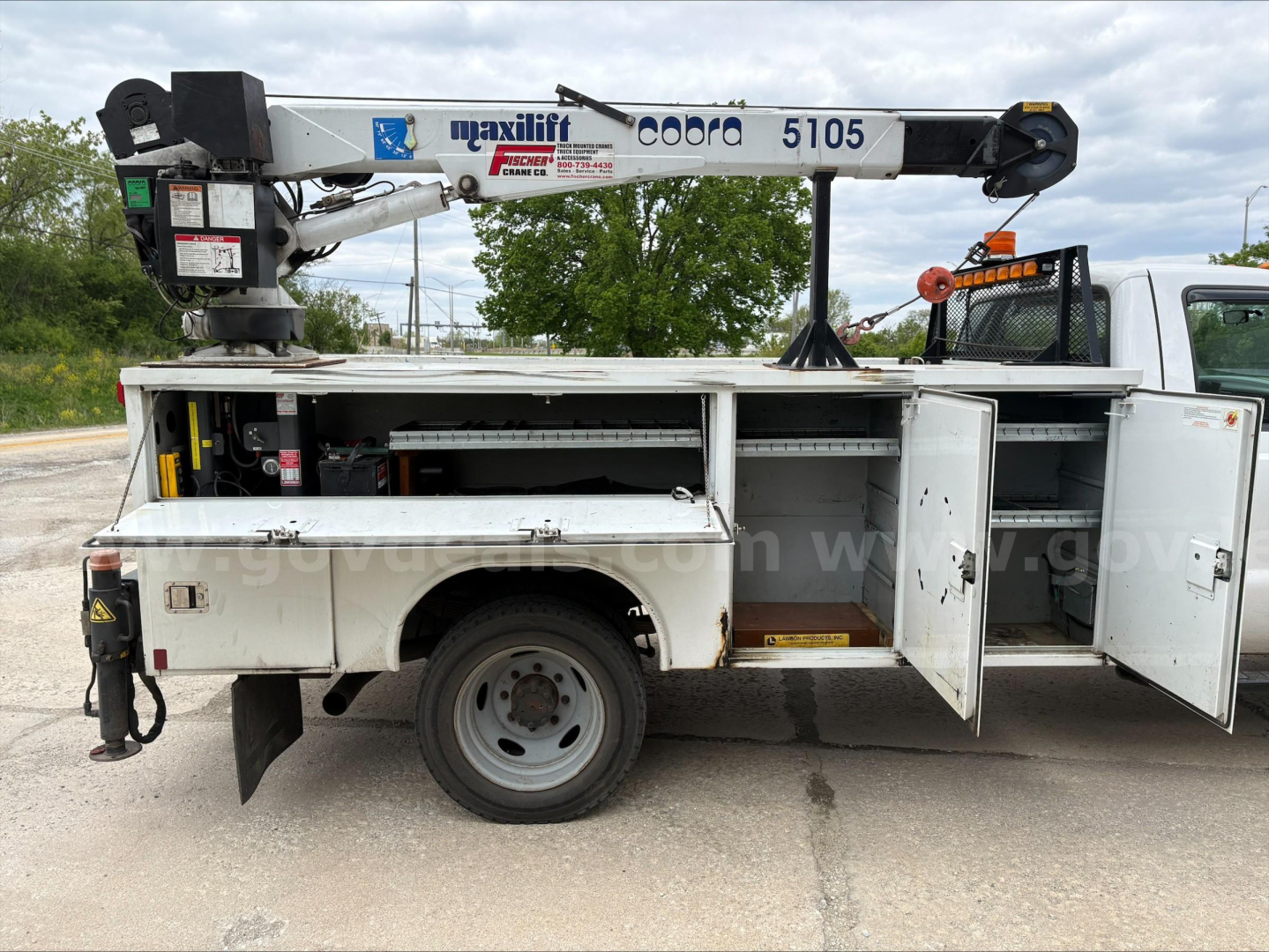 Service/utility truck with mounted crane, side doors open showing compartments and tool storage