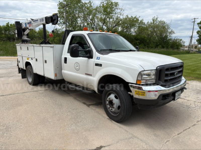 2004 Ford F450 service truck with utility bed and crane, in-service, side view showing utility compartments and crane equipment.