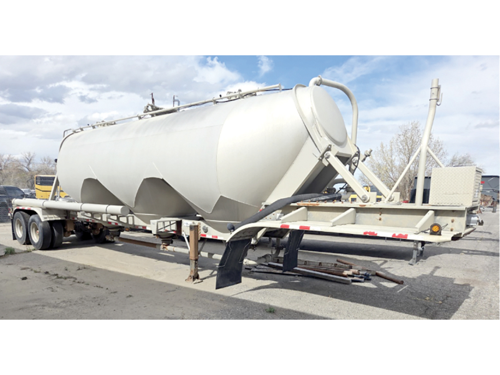 Aluminum pneumatic tanker trailer in service showing cylindrical tank with dual rear axles and hitch, used condition.