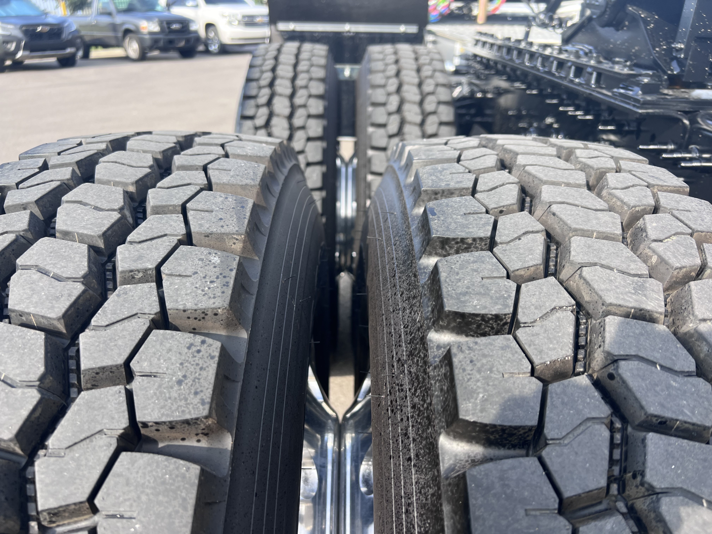 Twin rear tires of a 2026 Mack PI64T truck showing heavy tread blocks and sidewall texture.