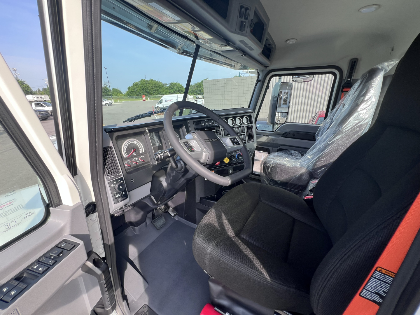 Cab interior of 2026 Mack PI64T showing steering wheel, dashboard gauges, and driver seat.