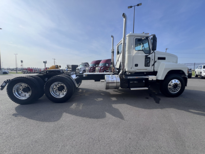 White 2026 Mack PI64T semi tractor truck in a lot, side view showing dual rear axles, fuel tanks, exhaust stacks, and cab with chrome accents.