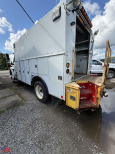 Service body truck rear and side view showing compartments and open access at rear with steps and yellow transfer box.